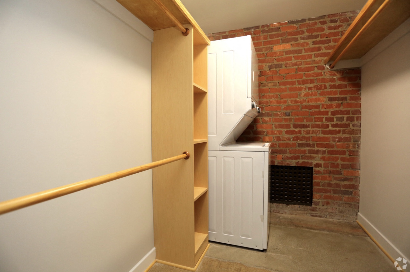 the stairway to the basement has a brick wall and a white door