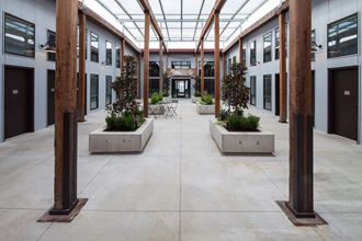a courtyard with benches and trees in the middle of a building
