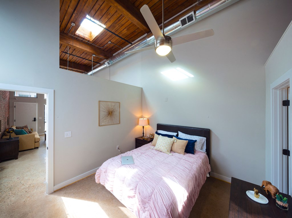 a bedroom with a bed and a ceiling fan
