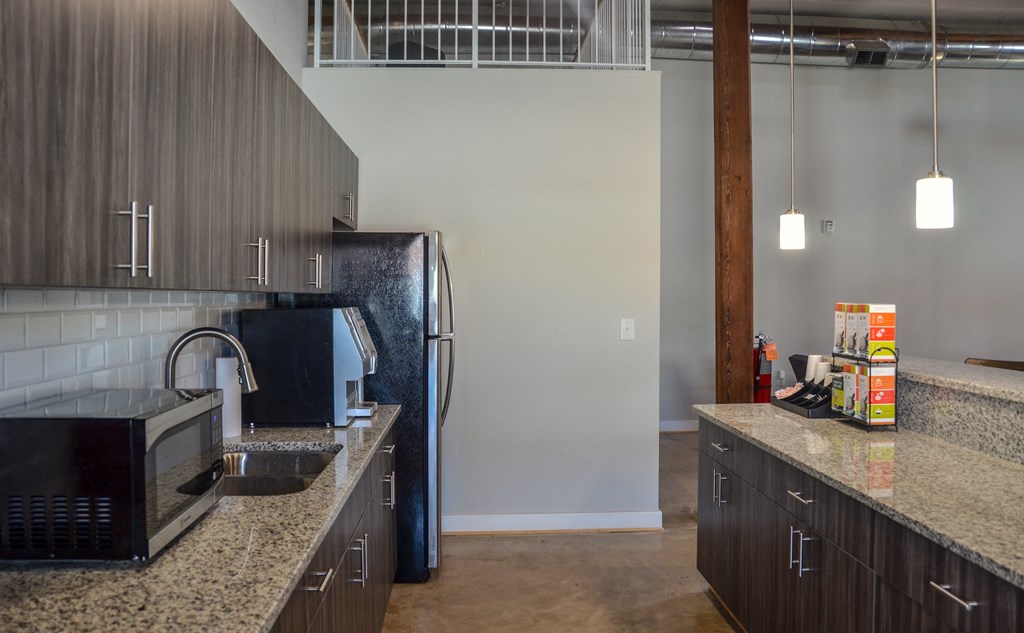 a kitchen with granite counter tops and a stainless steel refrigerator