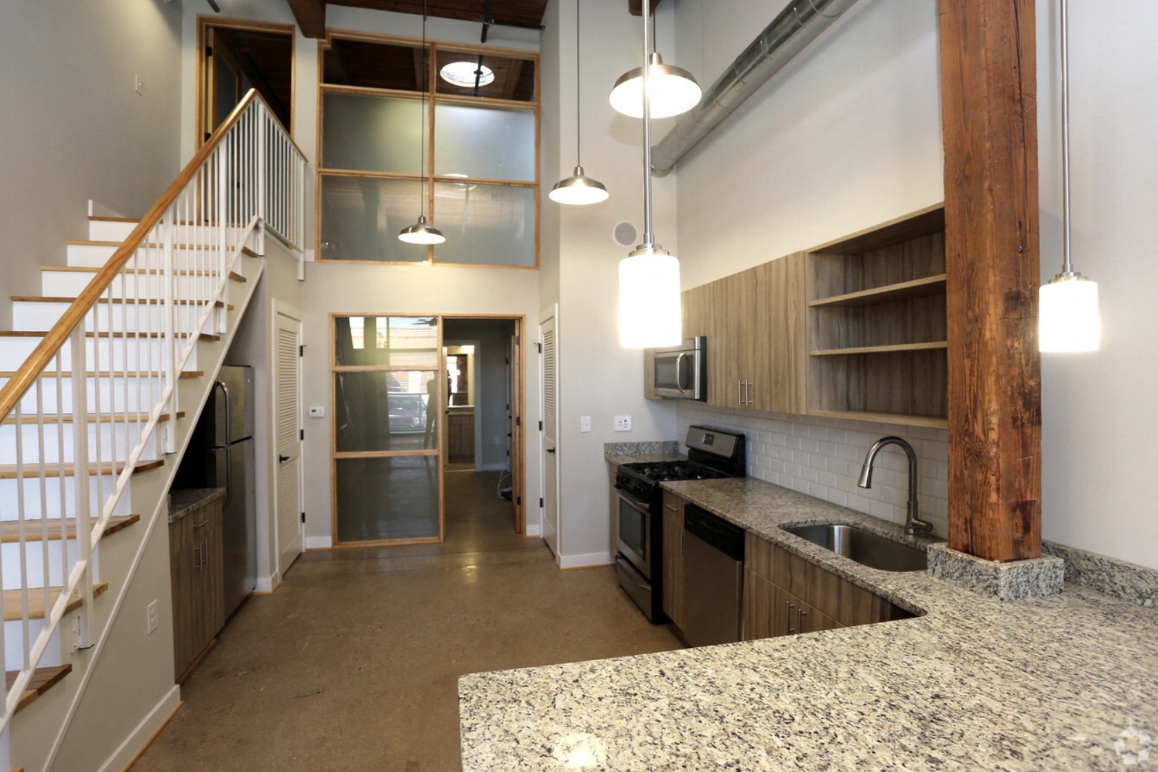 a kitchen with a sink and a stove and a staircase