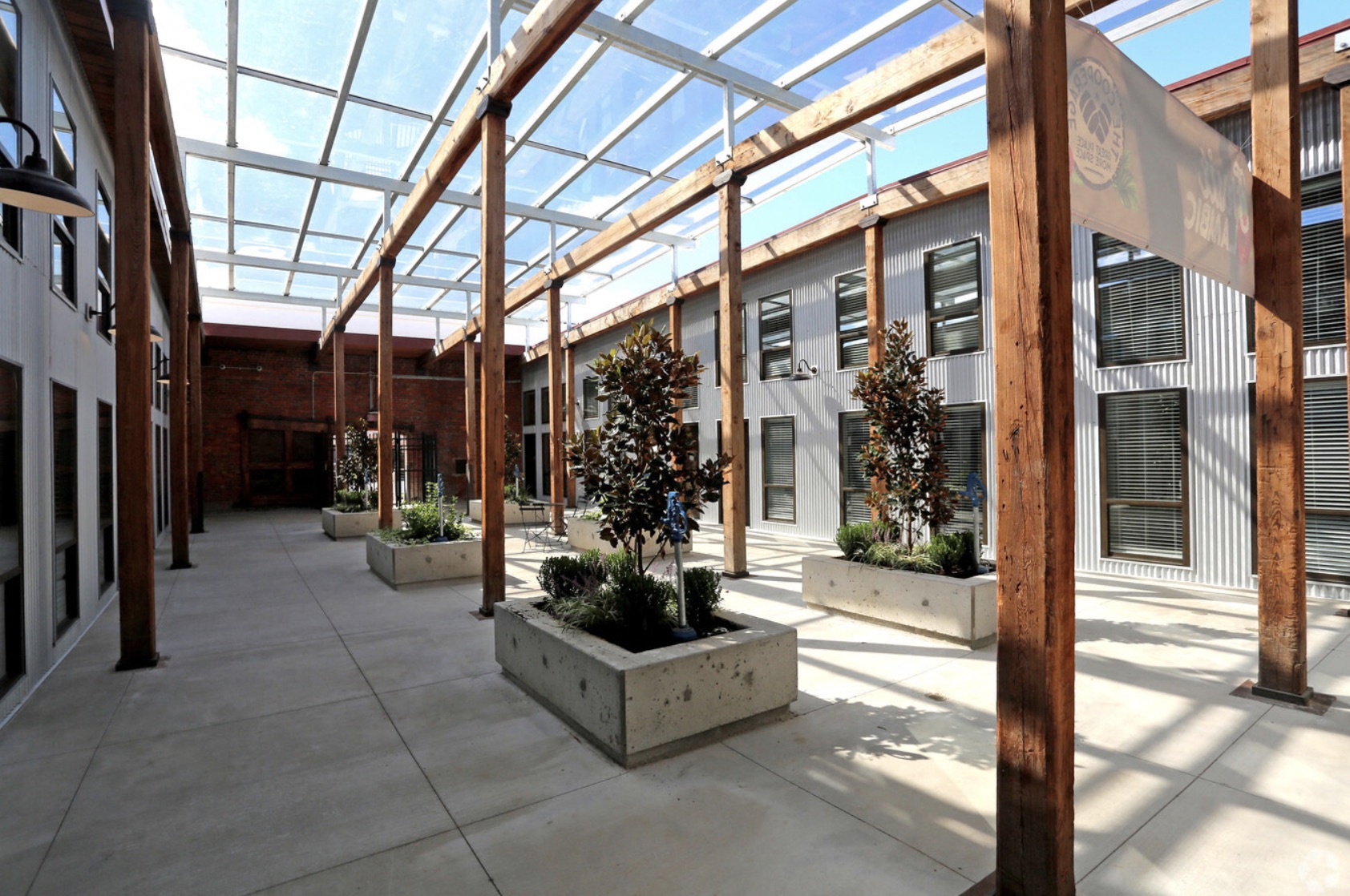 the courtyard of a building with potted plants and a glass roof