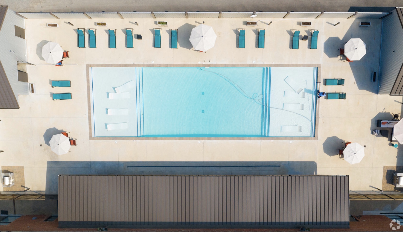 arial view of a swimming pool in a building with tables and umbrellas