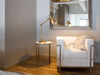 a living room with a white chair and a side table