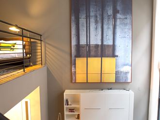 a bedroom with a bunk bed and a painting on the wall
