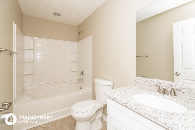 a bathroom with a toilet and a tub and a sink