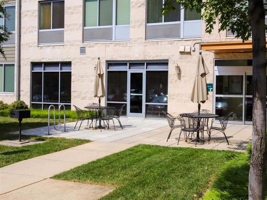 a patio with tables and chairs outside of a building