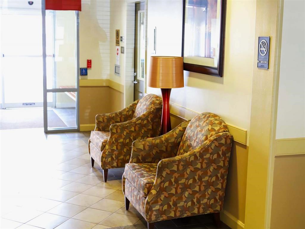 two chairs sitting in a lobby next to a lamp