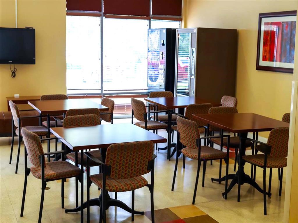 Community Room a dining room with tables and chairs and a tv
