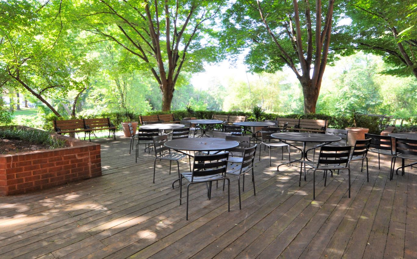 the patio is filled with tables and chairs and trees