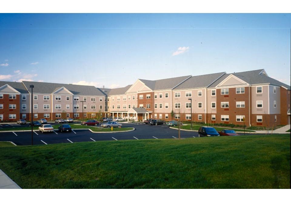 an exterior view of an apartment building with a parking lot