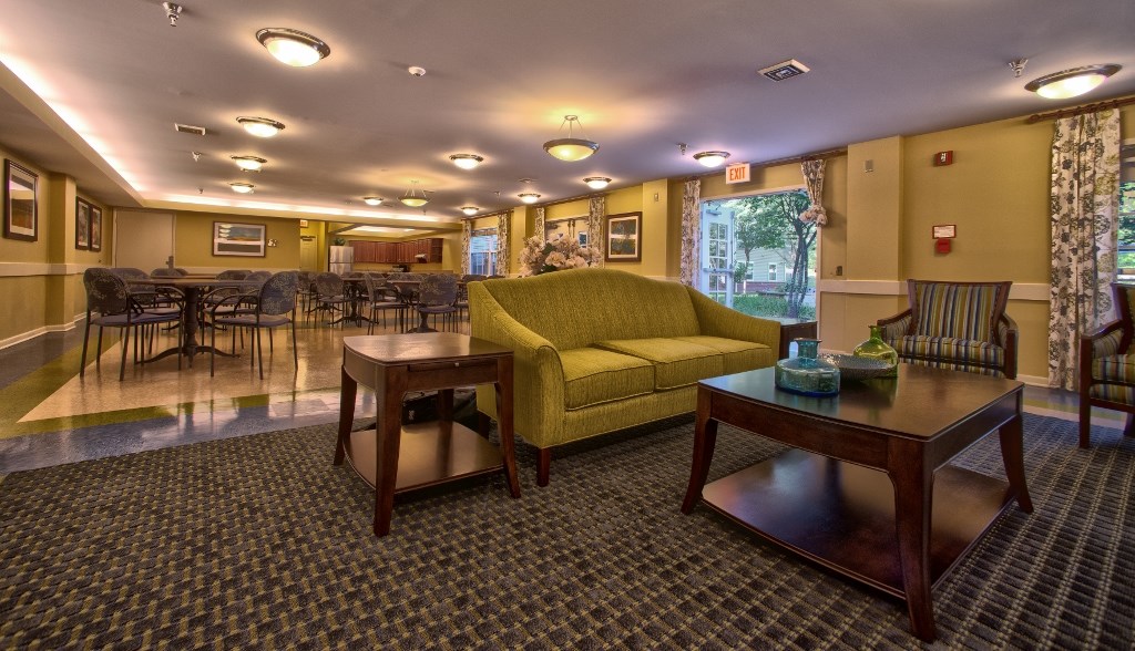 a living room with a yellow couch and tables