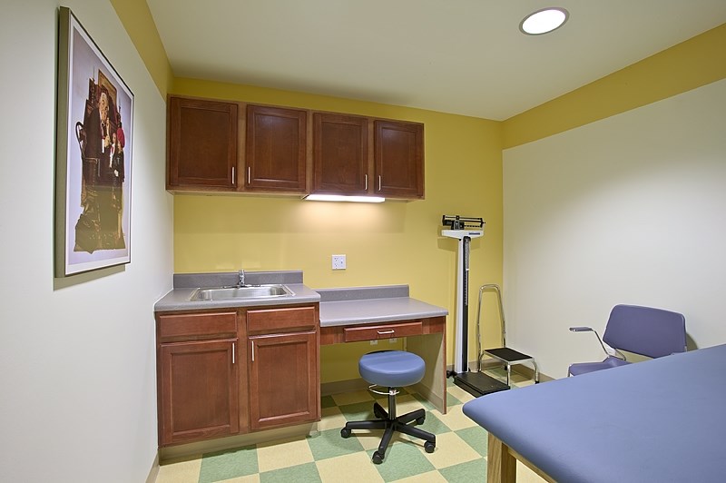 a room with a desk and a chair and a sink