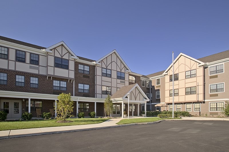 an exterior view of an apartment building with a parking lot