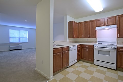 an empty kitchen with wood cabinets and white appliances