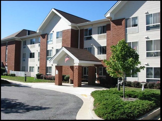 an apartment building with a tree in front of it