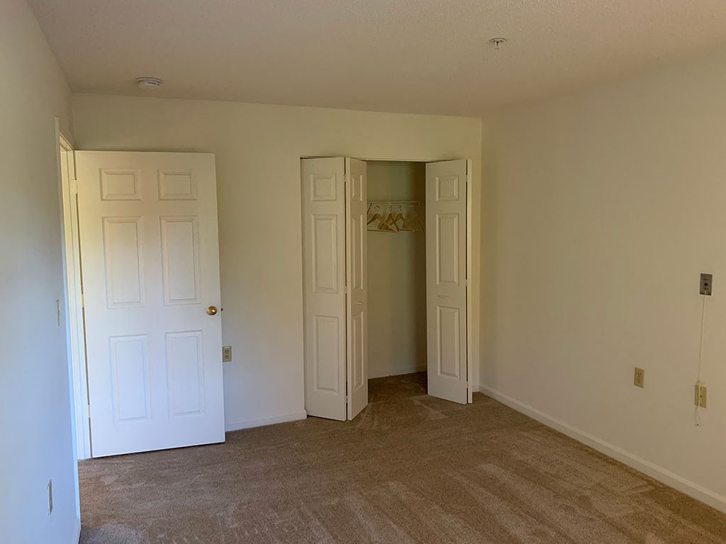 a living room with two doors and a door to a closet