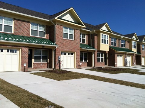A row of houses with garages and driveways.