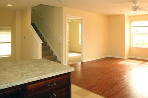 A room with a marble counter top and wooden floors.