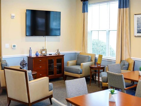 a living room with chairs and tables and a television