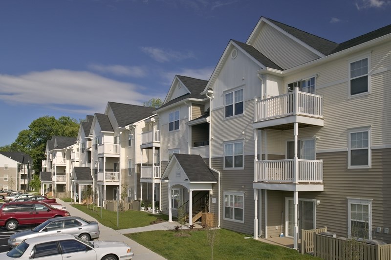 a row of houses with cars parked in front of them