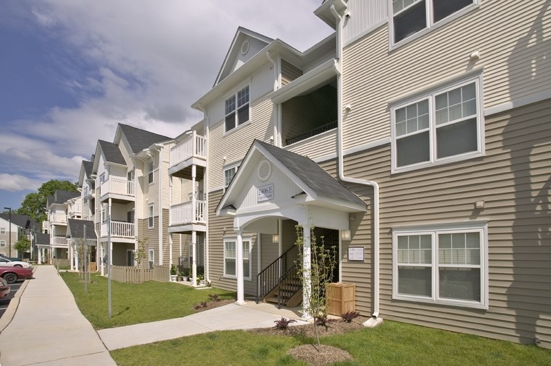 a row of town houses with a sidewalk in front of them