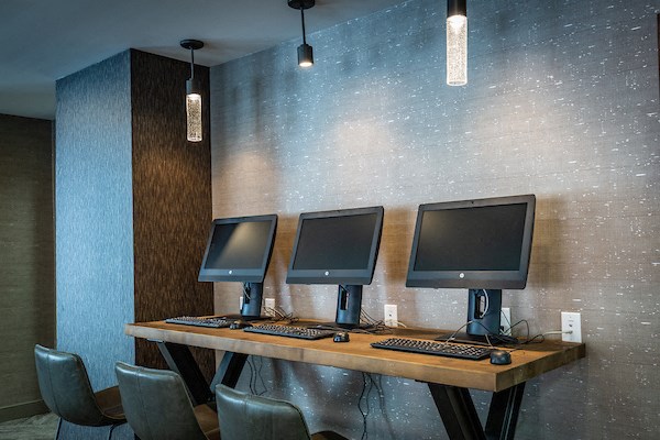 three computer monitors on a desk in a room