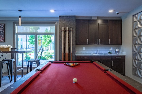 a red pool table in the center of a kitchen with a bar