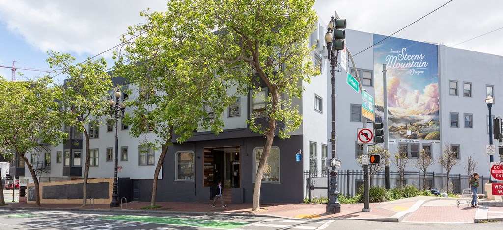 a large building on the corner of a street with trees