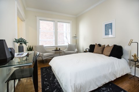 a bedroom with a bed and a desk and a window