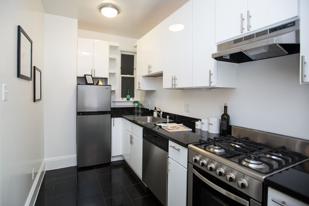 a kitchen with white cabinets and stainless steel appliances and a stove