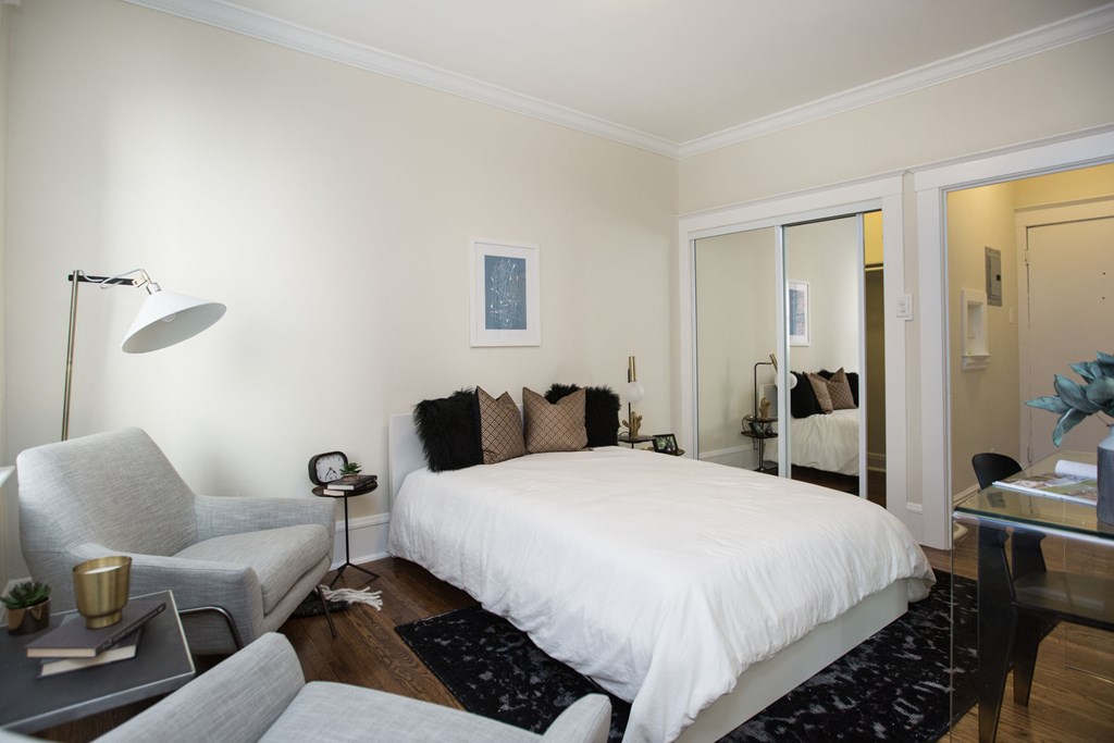 a bedroom with a bed and a couch and a living room