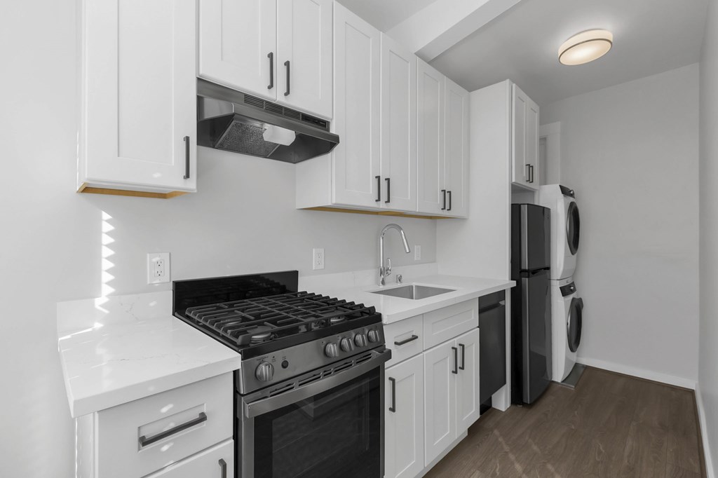 a kitchen with white cabinets and black appliances and a sink
