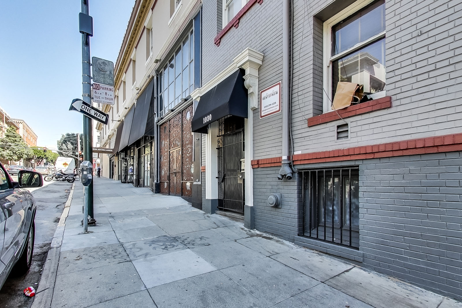 A street view of a building with a black awning and a sign that says "Bakery".