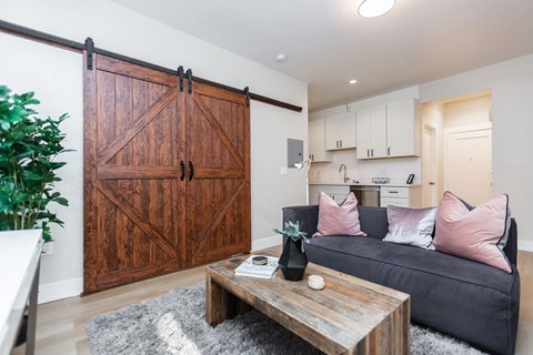 A living room with a grey couch and a wooden coffee table.