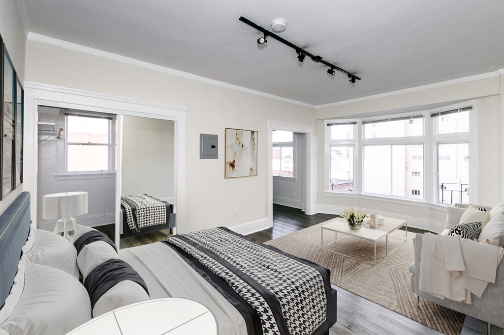 a bedroom with a bed and a living room with a couch and a coffee table