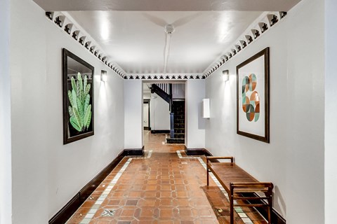 A hallway with a bench and pictures on the wall.
