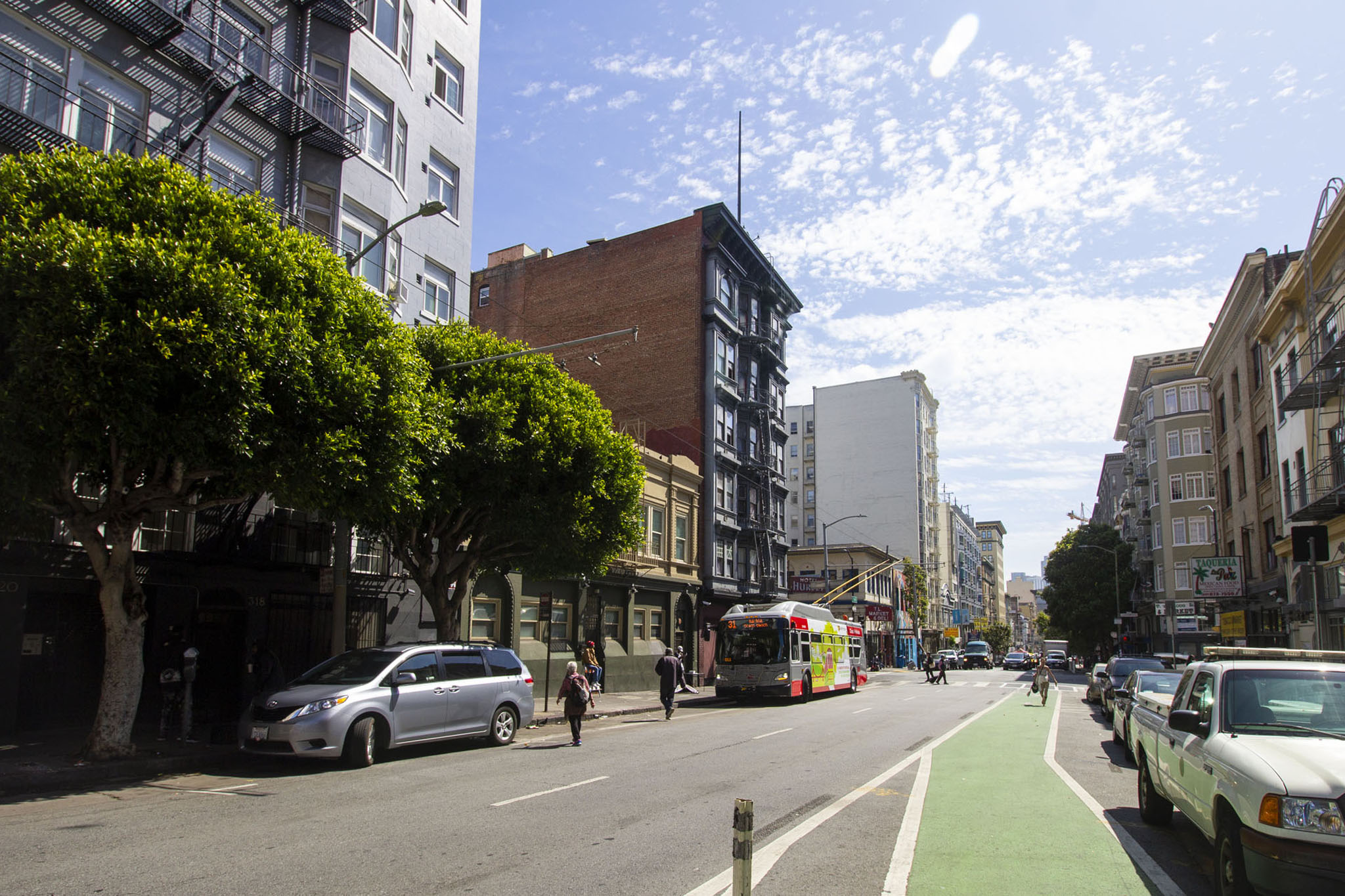 A city street with a green bike lane on the right side.