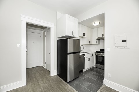 A kitchen with a black refrigerator and stainless steel appliances.