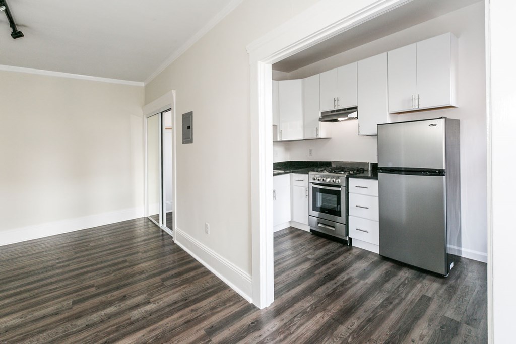 a renovated kitchen with white cabinets and stainless steel appliances
