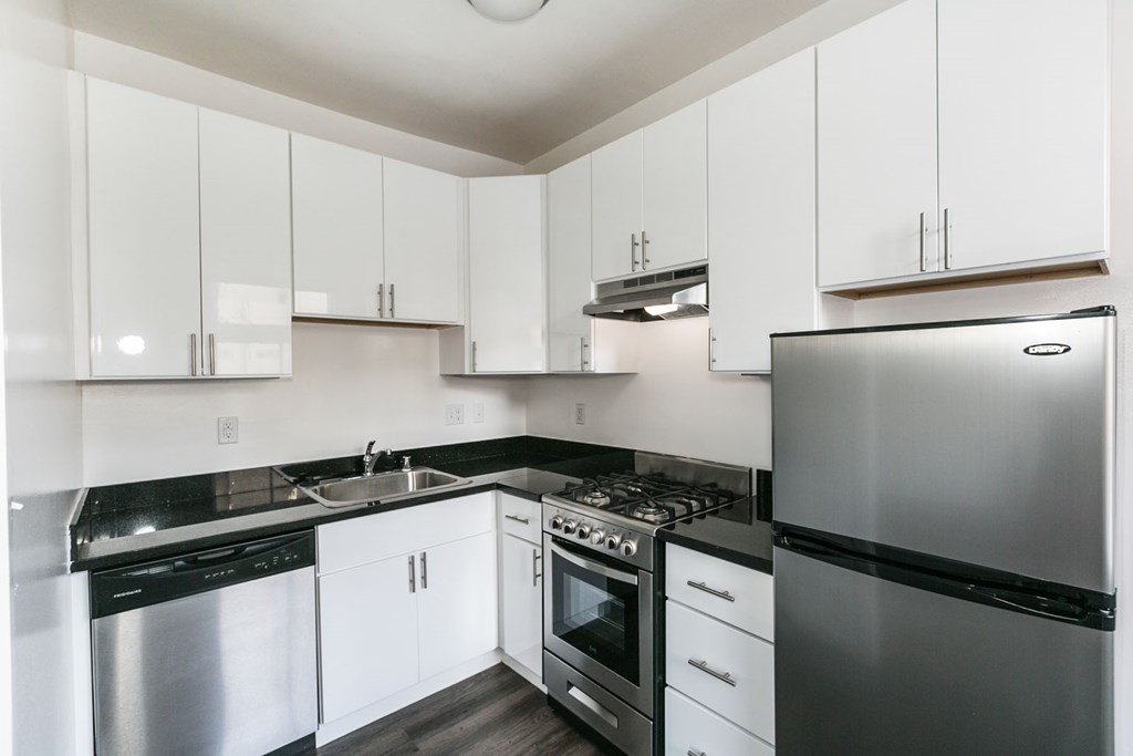 a kitchen with white cabinets and stainless steel appliances