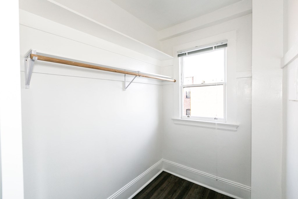 a small room with a window and a white closet