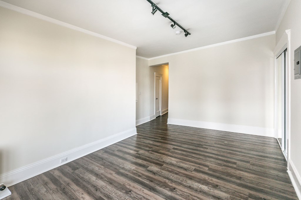 an empty living room with white walls and wood floors
