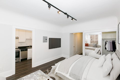 A bedroom with a large bed and a flat screen TV mounted on the wall.
