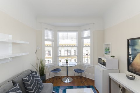 A living room with a grey couch and a white cabinet.