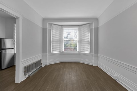 A room with a window and a radiator on the wall.