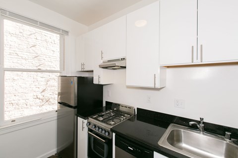 A kitchen with black countertops and white cabinets.
