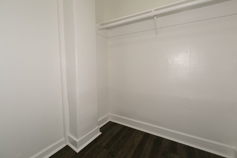 A white wall with a wooden floor.