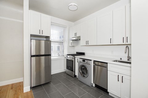 A kitchen with a stainless steel refrigerator, dishwasher, and oven.