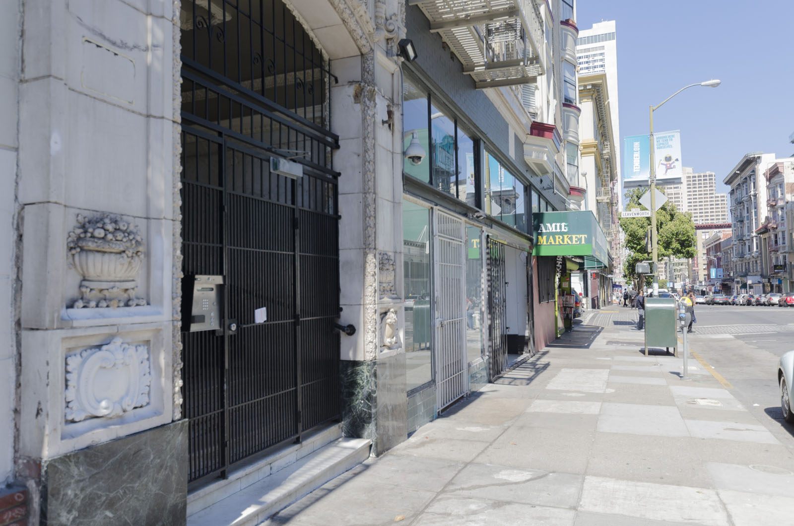 A street view of a city with a building that has a sign that says "Jim's Market".